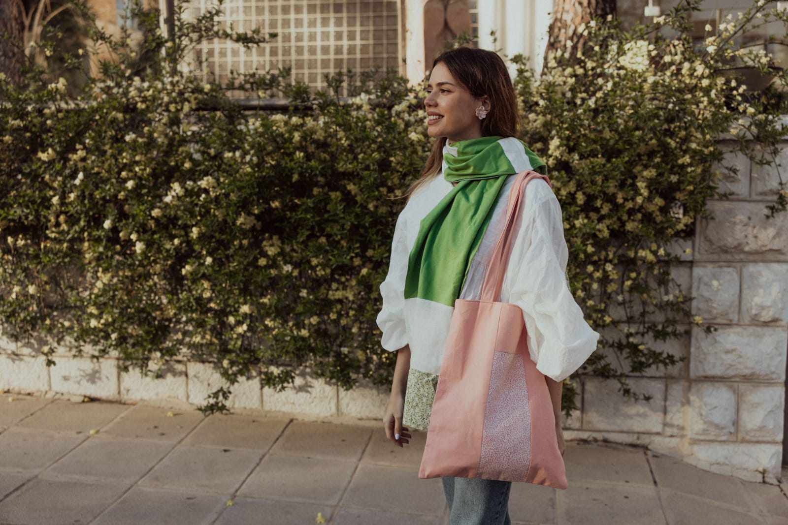 Pink patchwork tote bag carried with a green silk scarf on an Amman street